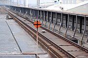 東北新幹線大宮駅構内に設置されている添線式軌道回路（前方）、手前にある標識は敷設箇所を示す停止限界標識。