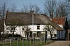 Boerderij, gepleisterd dwarshuis, goed oorspronkelijke type, dwarshuis aan de Zuidzijde eindigend in topgevel