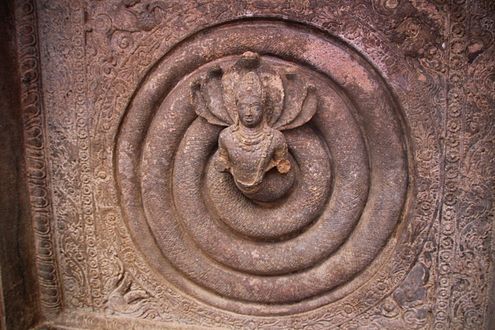 Një skalitje në çatinë e shpellës duke paraqitur një hyjni gjarpër me shumë koka, me gjasa Adisesha.