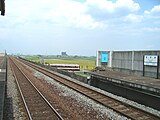 当駅西側ホームから河原田方面。高架下を近鉄鈴鹿線の列車が走行する様子が見える（2006年5月）