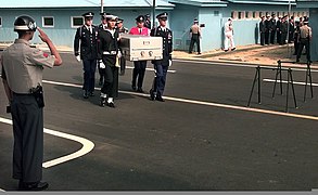 A ROK Army Guard salutes the transfer case of what is believed to contain the first of five U.S. soldiers killed in the Korean War who were repatriated during a ceremony at the Panmunjom Freedom House 981009-F-FC975-503.jpg