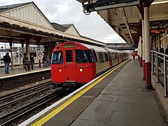 De metro uit de stad rijdt Harrow & Wealdstone binnen.