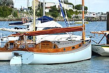 Cruising catboat showing classical rudder design and wire stays supporting the mast