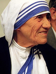An image of Mother Teresa wearing a white head with blue stripes