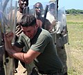 A US Marine participates in a BDF training exercise concerning crowd control