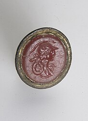 Bronzen stempel met een rode steen, met decoratie van een gehelmde godin mogelijk Minerva of Roma