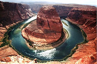 Horseshoe Bend o "Corba de la ferradura" en Arizòna. Als environs arids, las corbas augmentan considerablament lo linear de vegetacion rivulària.[2]