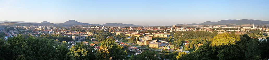 Panorama Prešova z vrchu Kalvárie. Vlevo Šarišská vrchovina s Šarišským vrchem a Šarišským hradem, uprostřed centrum a věž sv. Mikuláše, za níž je slabě patrný Kapušanský hrad, vpravo v popředí areály Prešovské univerzity, sídliště Sekčov a Slanské vrchy.