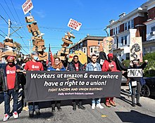 Six people holding a black banner