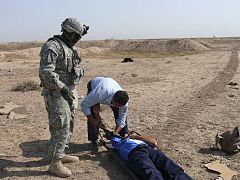 US Army 53444 BAGHDAD-Kericho, Kenya native, Spc. Lawrence Rotich (left), a combat medic with H Troop, 1st Squadron, 7th Cavalry Regiment, 1st Brigade Combat Team, 1st Cavalry Division, observes as an Iraqi policem.jpg