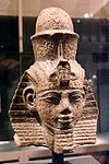 Le pharaon Amenhotep III et ses attributs, la coiffe-némès, le pschent, la barbe postiche et l’uræus.