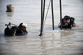 US Navy 091116-N-4154B-071 Navy Diver 2nd Class Zachery Dojaquez and an Iraqi Navy diver work together to run lifting wires from a crane to a sunken barge.jpg