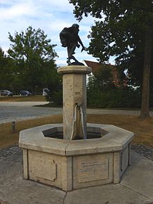 Ein achteckiger Brunnen mit einem Moriskentänzer darauf.