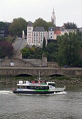 Un bateau sur la Loire, au second plan, sur une colline, un bâtiment blanc longé par un escalier.