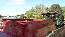 The back of a red steam locomotive tender with the inside of the steam locomotive's cab partially visible