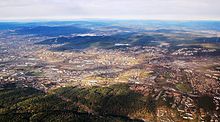 Luftbild eines von Wald umgebenen städtischen Gebietes