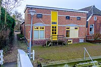 Achterzijde van het dorpshuis gezien vanaf het hoogholtje. Tot 1975 zat hier café De Molen.