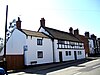 A pair of two-storey rendered cottages with a timber-framed upper floor