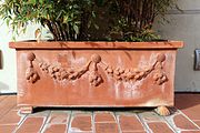 Terraacotta planter in Italy, decorated with festoons