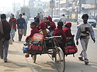 Skoleelever som passasjerer på sykkelrickshaw i Lucknow i India, 2005.