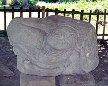 Escultura de piedra con forma de cabeza de un animal mirando a la izquierda