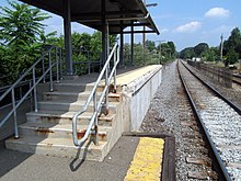 A section of high-level railway platform. The section of platform edge nearest the track is missing, with some damage to the concrete visible