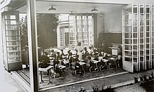 Photographie en noir et blanc d'une salle de classe.