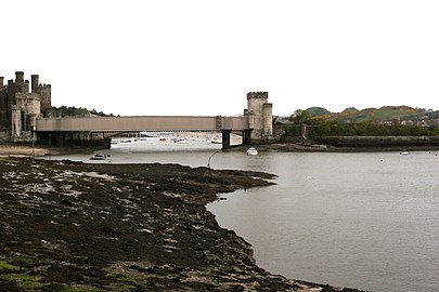 Yr afon yn llifo dan y ddwy bont yn nhref Conwy tua'r môr