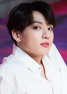 Jungkook looks up to the right, against a purple background