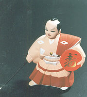 A dancing Hakata ningyō doll holding a large sakazuki (Kuroda bushi)