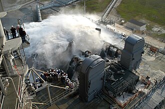 Workers and media watch a water suppression system test.