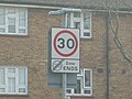 A British speed limit sign in a residential area.