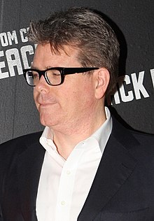 Christopher McQuarrie portant des lunettes, une chemise et une veste.