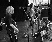 Black-and-white photo of a punk band performing live