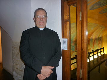 Il sagrestano della chiesa di San Giacomo a Sydney di fianco alla cappella dei bambini nella cripta della chiesa che utilizza QRpedia.