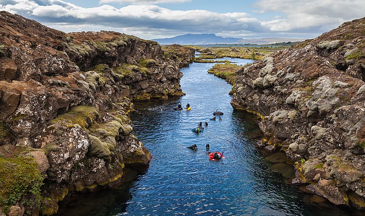 Любители подводного плавания в рифтовом каньоне Сильфра в национальном парке Тингведлир (Исландия)