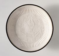 Ding ware dish with garden landscape, "molded stoneware with impressed decoration, transparent glaze, and banded metal rim", 13th century, diameter 5.5 in. (14 cm)
