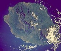 Réunion from space (NASA image). The three cirques, forming a kind of 3-leafed clover shape, are visible in the central north west of the image. Piton de la Fournaise, in the south east, is covered by cloud.