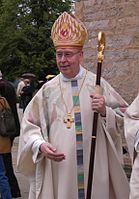 Tijdens de liturgie draagt een bisschop een mijter en houdt hij een staf in de hand.