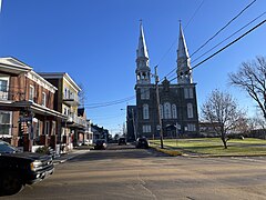 Coin des rues Notre-Dame et Saint-Paul, commerces, résidences privées et église catholique