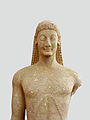 Vooraanzicht van een kouros, die de karakteristieke archaïsche haarstijl toont (Archeologisch Museum, Thebe)