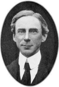 Portrait photographique en noir et blanc, dans un médaillon ovale, d'un homme souriant, portant un haut col rigide et une cravate noire.