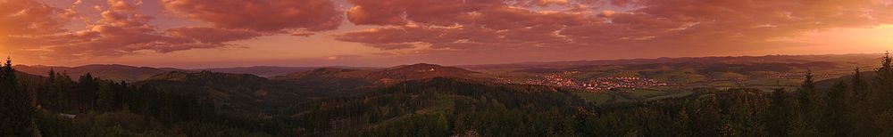 Panoramatický výhled z rozhledny Královec při východu slunce, Poteč se nachází v první pětině obrazu zprava