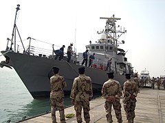 US Navy 080813-N-5068C-014 Iraqi sailors look on from the pier as the coastal patrol boat USS Firebolt (PC 10) arrives at the port of Umm Qasr.jpg