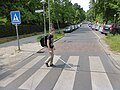 Überqueren auf einem Zebrastreifen neben einer Aufpflasterung, int. „schlafender Polizist“ genannt.