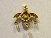 Pandantivul cu Albine, o bijuterie minoică reprezentativă; 1700-1600 î.Hr.; aur; lățime: 4.6 cm; din Chrysolakkos (groapă de aur), în Malia (Creta); Muzeul Arheologic din Heraklion[15]