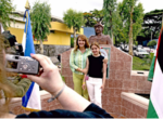 Descendientes de palestinos toman una foto junto a un busto de Yasir Arafat, San Salvador