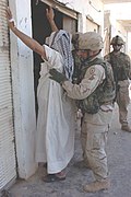 Staff Sgt. Jesse Wyant searches an Iraqi man - DVIDS 2004.jpg