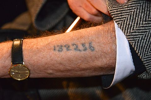 Memorial Ceremony at the Raoul Wallenberg square in Stockholm with Holocaust survivors. A participant shows number tattoo on the arm. 27 January 2013, International Holocaust Remembrance Day.