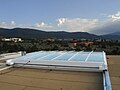 A large (20' x 20') steel and glass retractable skylight, seen from the roof. Note the steel tracks that the skylight rolls on, to retract.